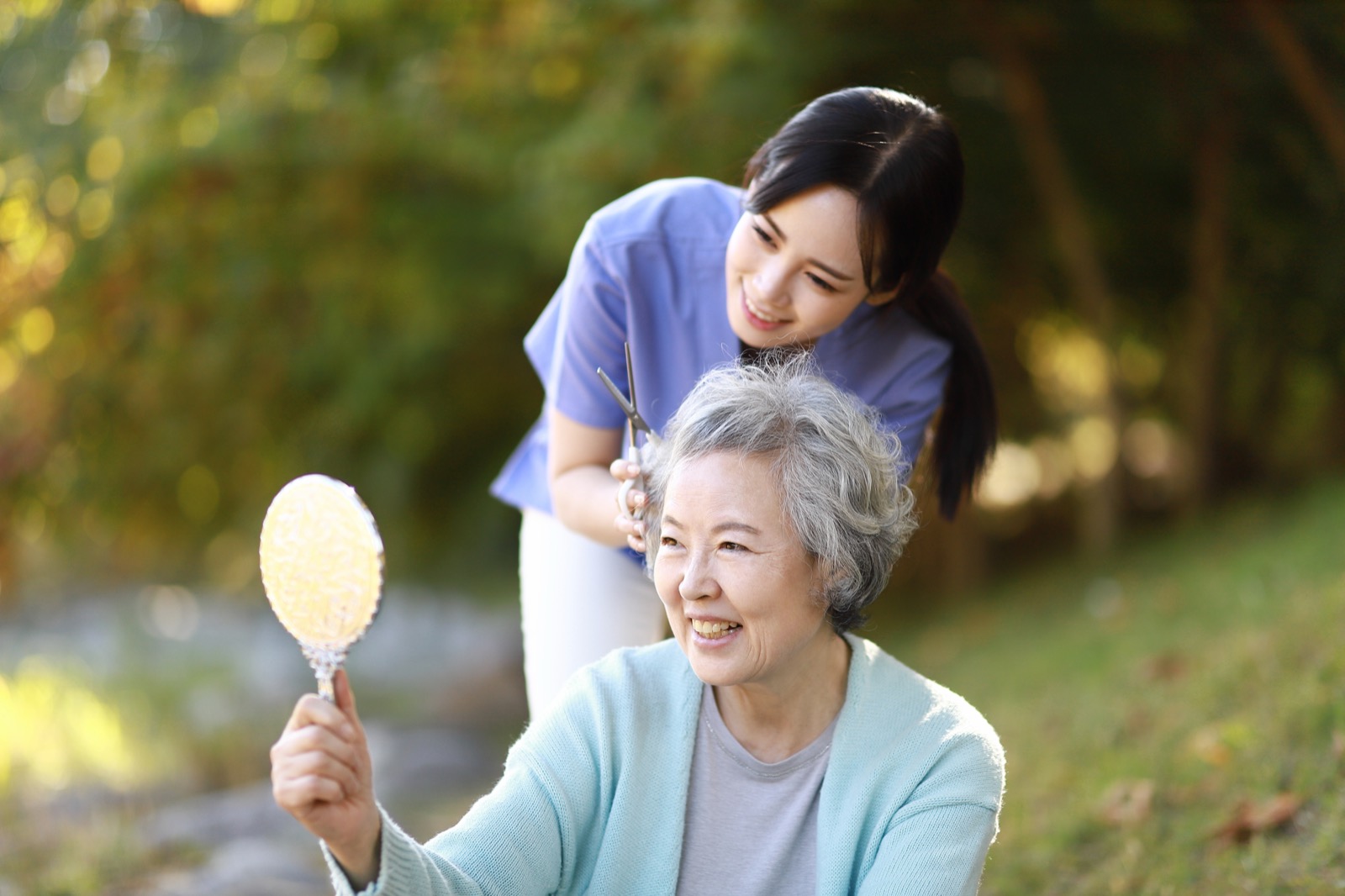 An older woman at home with her caregiver in the garden